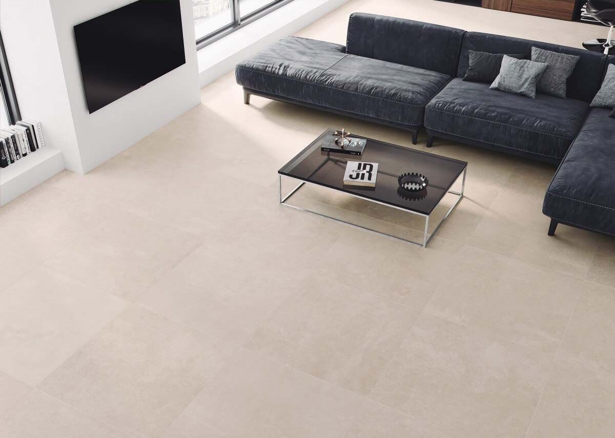 Sala de estar moderna con baldosas de color beige claro, sofá seccional gris oscuro y mesa de café negra.