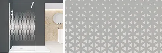 Interior de baño con pared de ducha con patrón geométrico gris y base de ducha blanca.