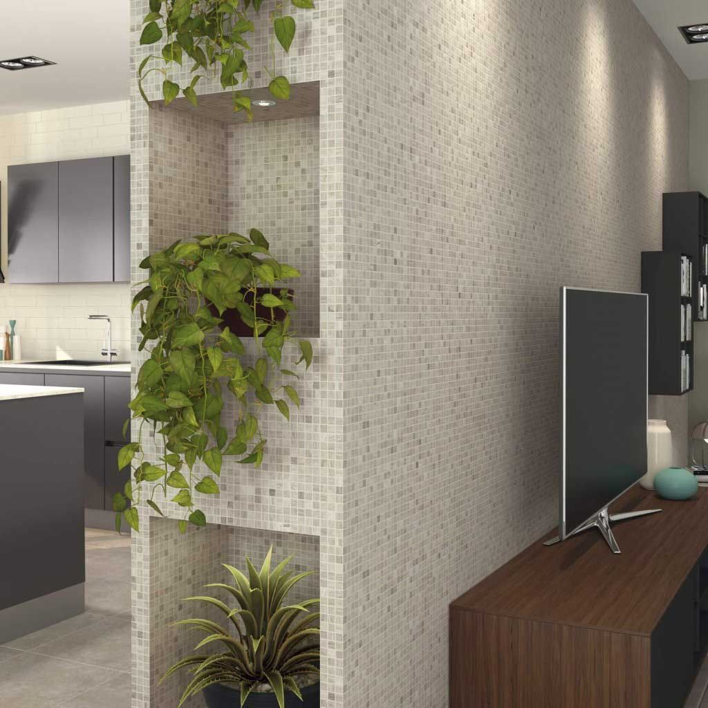 Biombo con mosaico y estanterías integradas para plantas. Interior con plantas, TV y cocina abierta.