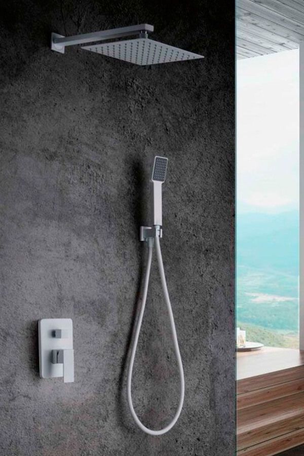 Artefacto de ducha moderno sobre pared gris, que incluye cabezal de ducha tipo lluvia, ducha de mano y controles de grifo.
