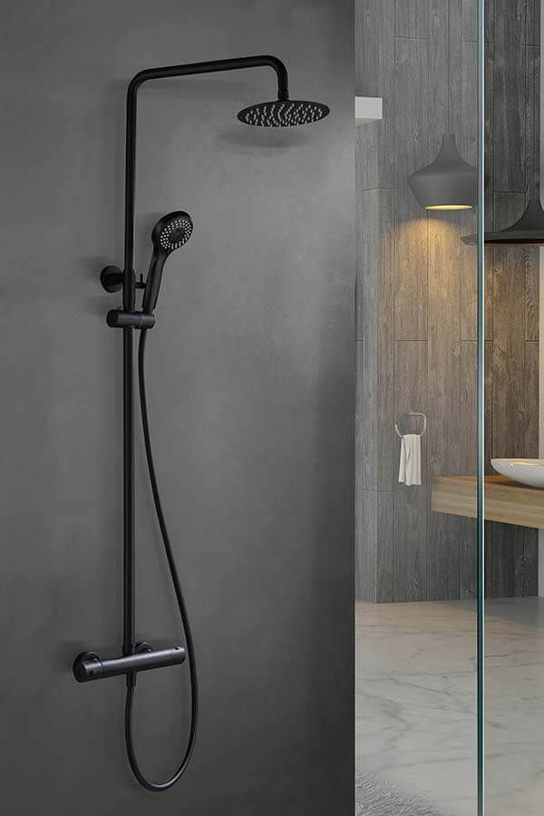 Sistema de ducha negro sobre una pared gris oscuro, con cabezal de ducha tipo lluvia y ducha de mano.