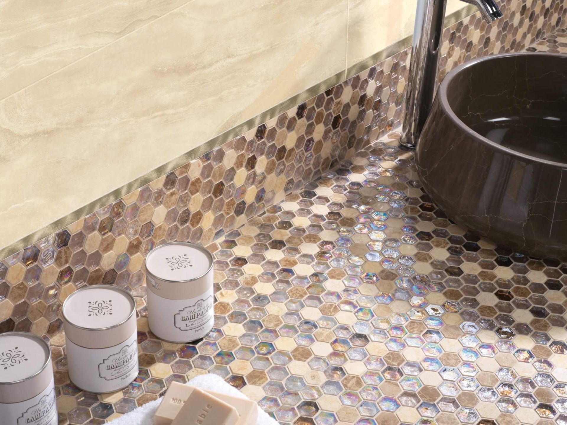 Encimera de baño con azulejos hexagonales y lavabo marrón oscuro. Tonos beige y marrón.
