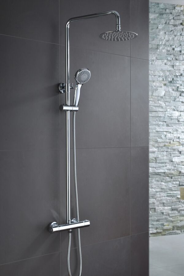 Sistema de ducha cromado con cabezal de ducha tipo lluvia y ducha de mano sobre una pared de azulejos grises.