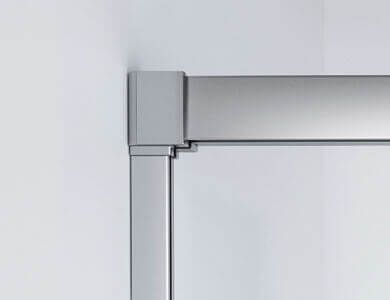 Marco de puerta de ducha de esquina en metal plateado, montado en una pared blanca.