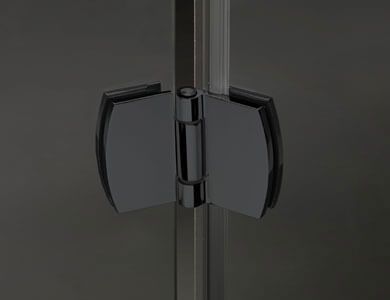 Bisagra cromada para puerta de ducha que conecta dos paneles de vidrio.