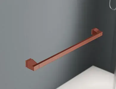 Barra de toalla de color cobre montada en una pared de baño gris.