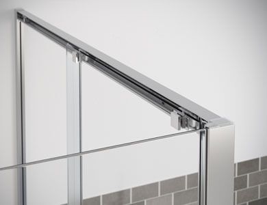 Marco de puerta de ducha cromado con paneles de vidrio y riel deslizante.