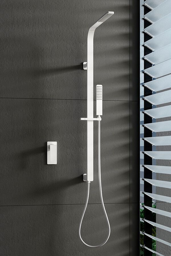 Accesorio de ducha plateado contra una pared oscura con una ventana con persianas de láminas.