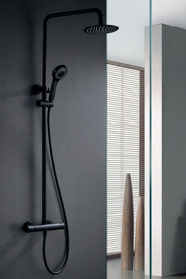 Sistema de ducha negro sobre una pared gris oscuro, con cabezal de ducha tipo lluvia y cabezal de ducha de mano.