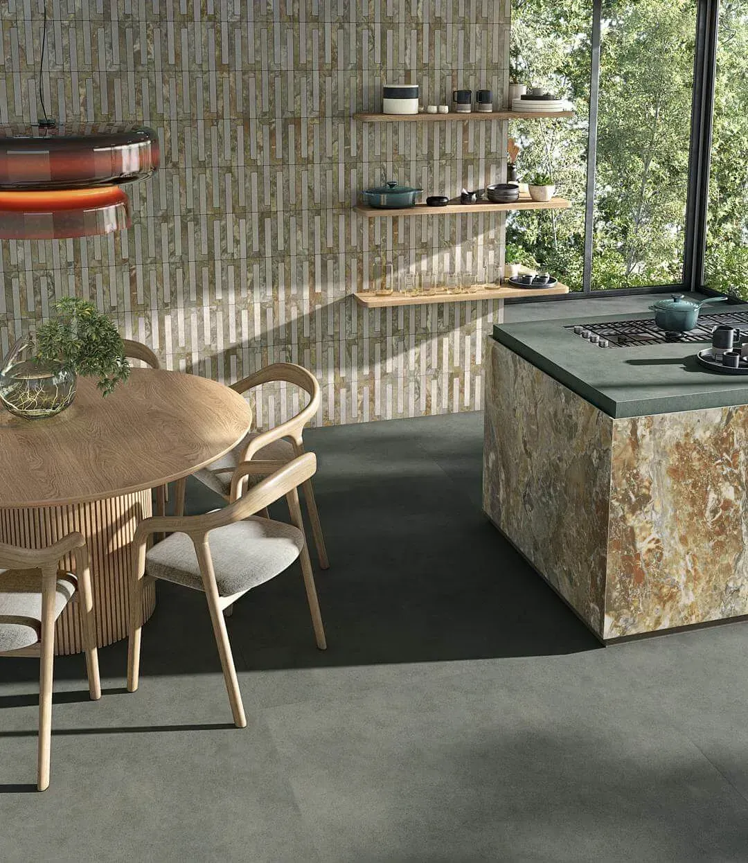 Cocina con paredes de piedra e isla, mesa redonda de madera, estanterías con vajilla y un gran ventanal con árboles.