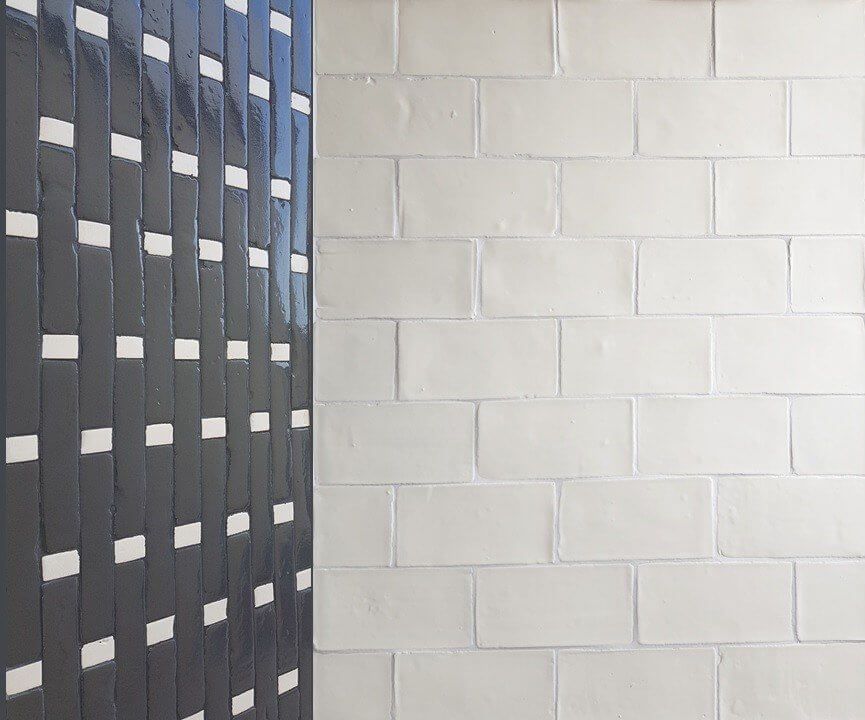 Panel de listones grises junto a una pared de ladrillo blanco.