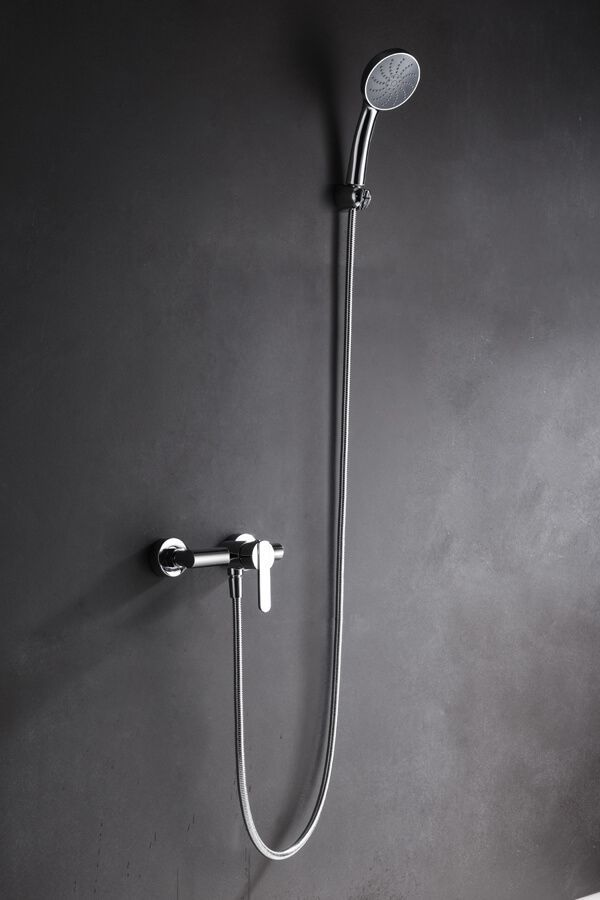 Artefacto de ducha cromado sobre pared gris oscuro.