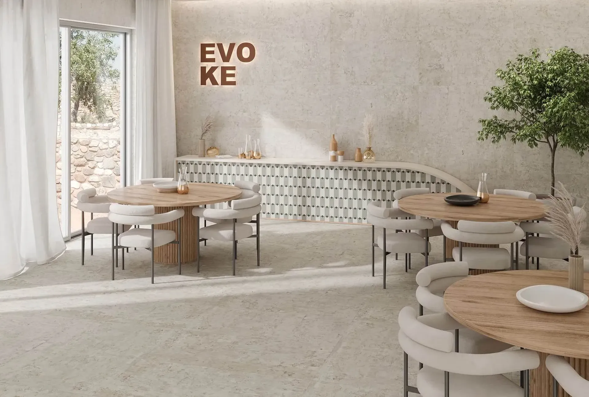 Interior de restaurante con mesas redondas de madera, sillas blancas y paredes texturizadas. Se ve el cartel 