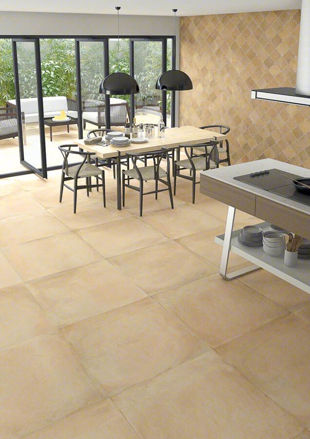 Cocina de concepto abierto con amplios ventanales y azulejos color canela. Mesa de comedor y sillas en el centro.