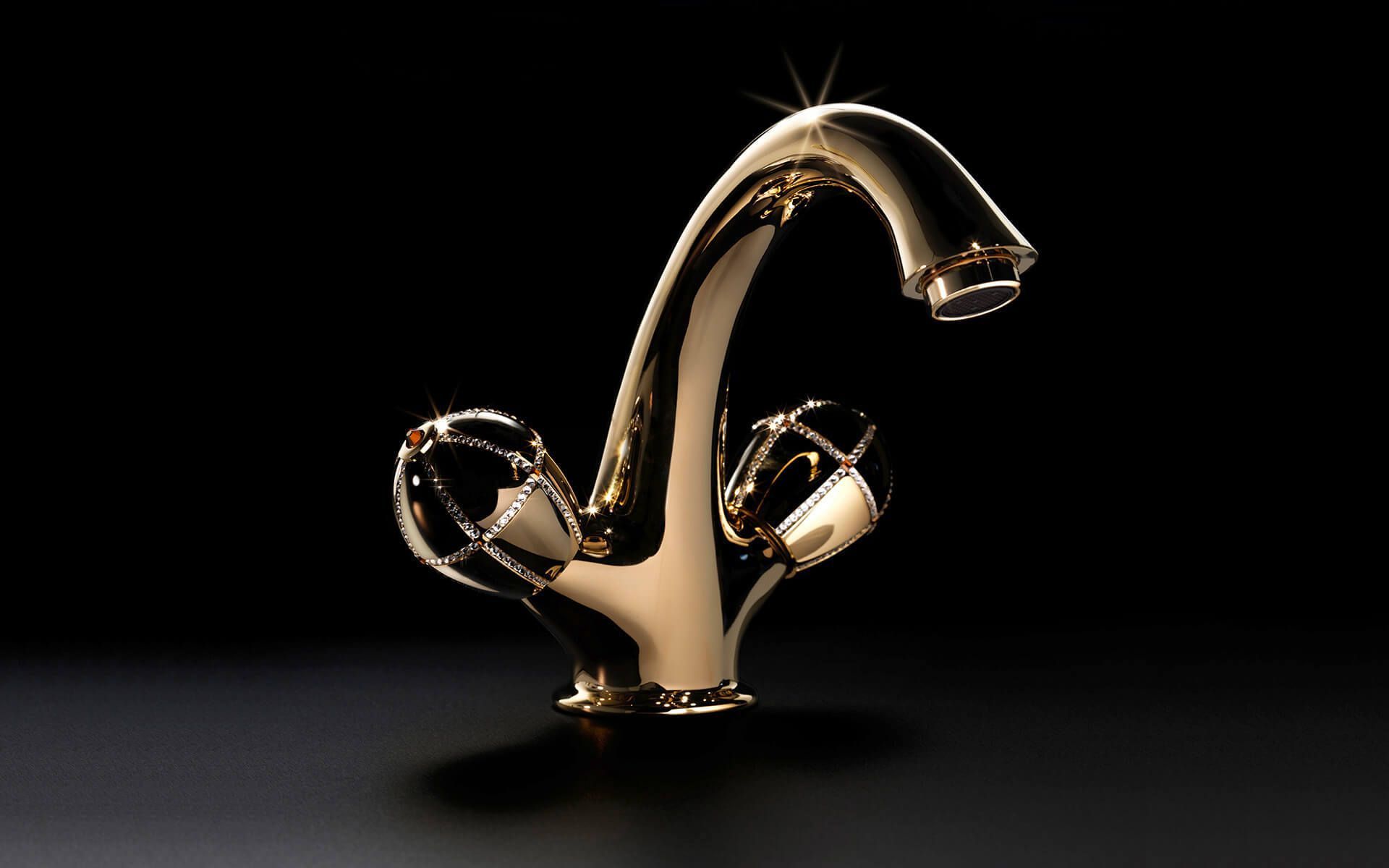 Grifo de color dorado con caño curvo y manijas, sobre un fondo oscuro.