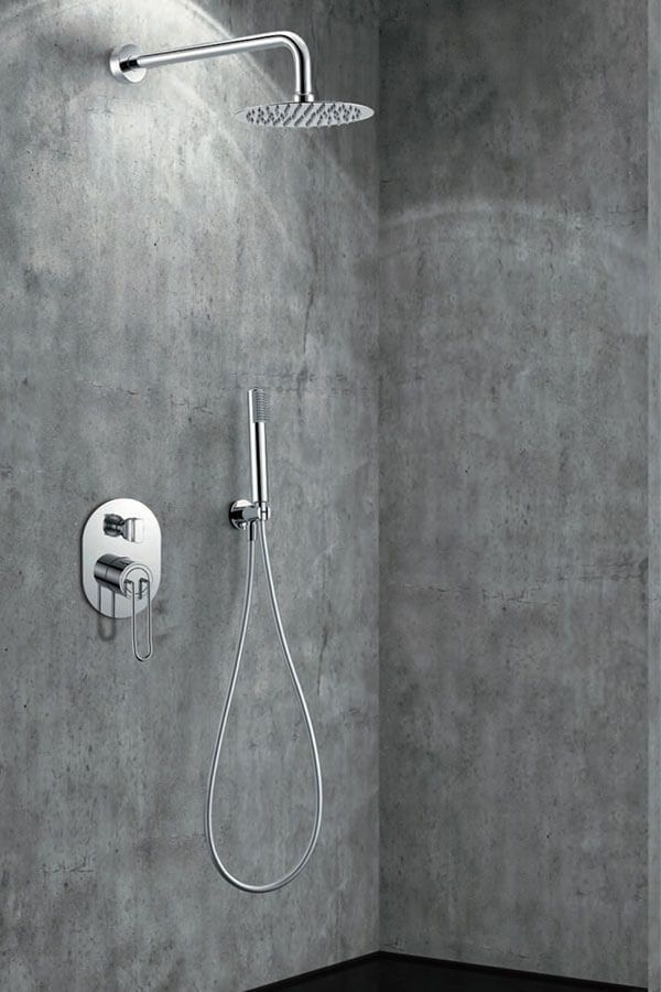 Juego de ducha sobre pared de hormigón gris; incluye ducha de lluvia superior, ducha de mano y panel de control.