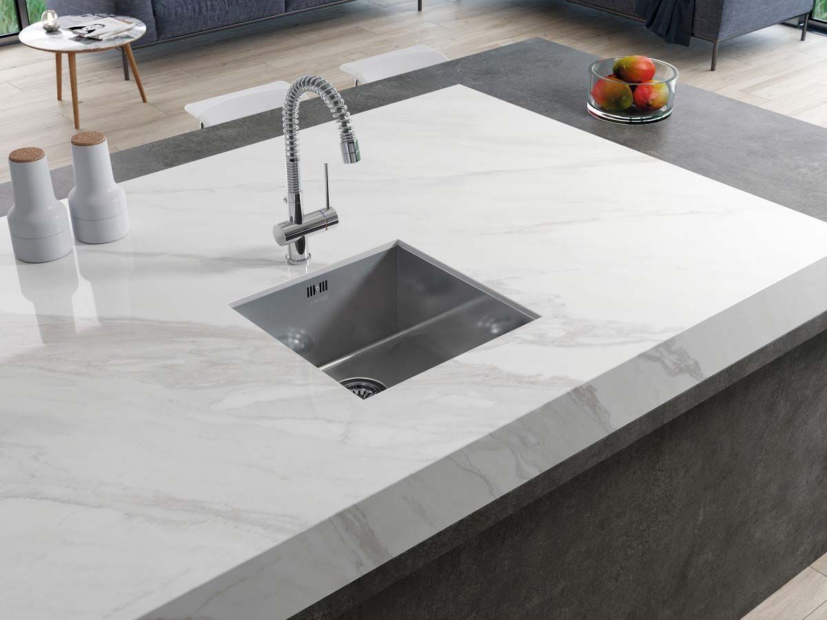 Isla de cocina moderna con encimera de mármol blanco, fregadero y grifo de acero inoxidable. Incluye frutero.