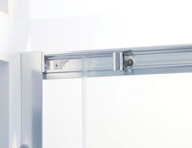 Primer plano de un riel para puerta corrediza de vidrio blanco con mecanismo de rodillo y marco.