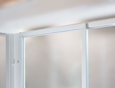 Puerta de ducha con marco blanco, paneles de vidrio esmerilado parcialmente visibles y riel deslizante.