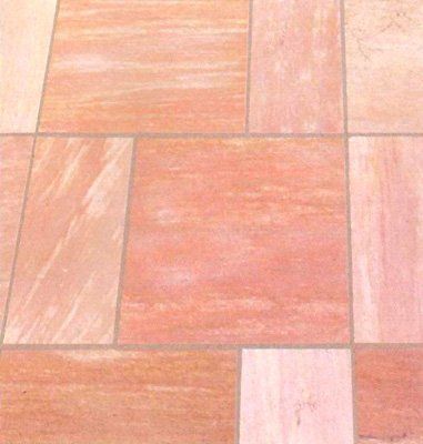 Baldosas de suelo de arenisca rosa y beige dispuestas en un patrón rectangular.