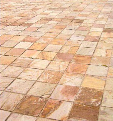 Piso de baldosas de piedra, varios tonos de marrón y tostado, en patrón de cuadrícula.