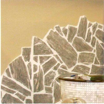 Esquina de una pared con un diseño pintado que imita la piedra. Debajo, una estructura redondeada de azulejos. Tonos tostados y grises.