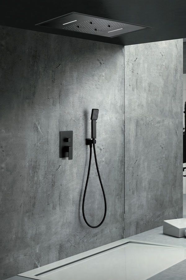 Ducha moderna con cabezal de ducha montado en el techo, ducha de mano y accesorios minimalistas de color gris oscuro contra una pared de hormigón.