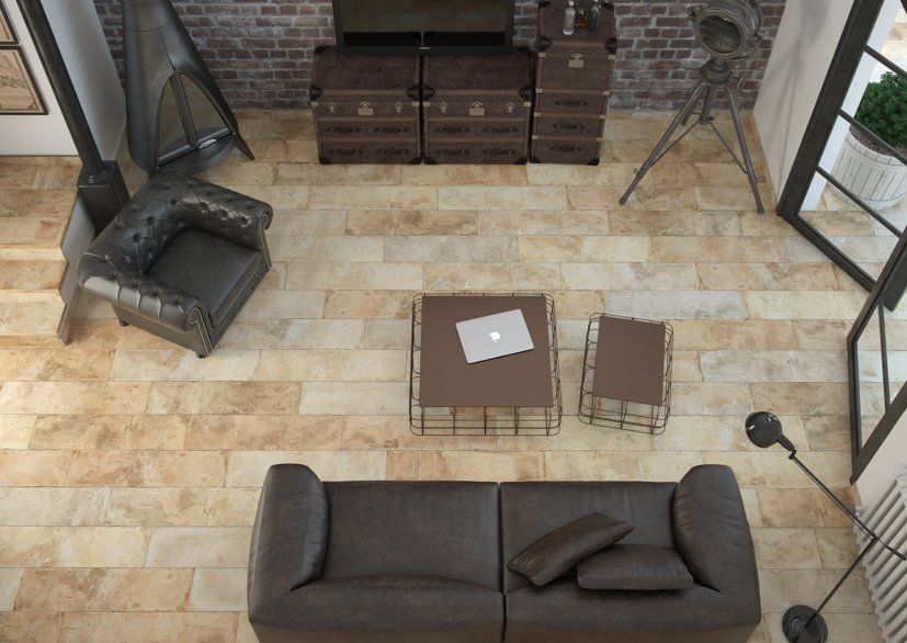 Vista aérea de una sala de estar con muebles de cuero, almacenamiento de madera y una computadora portátil en la mesa de café.