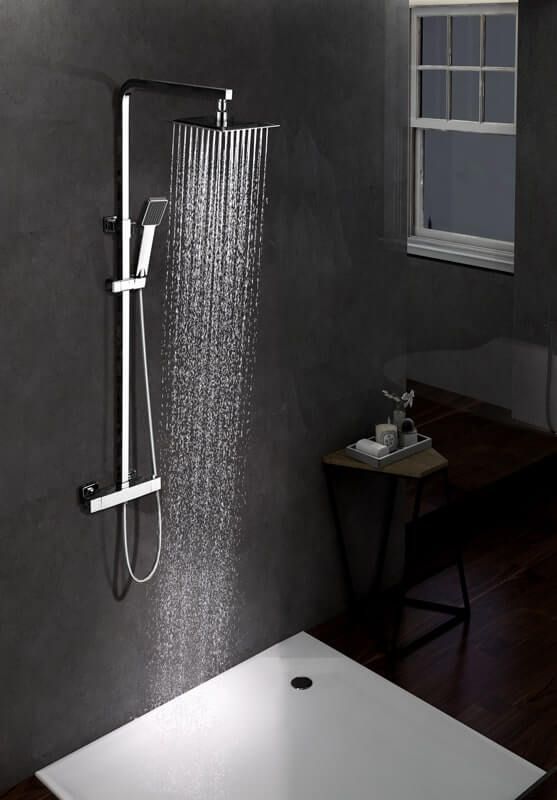 Ducha con cabezal de lluvia y ducha de mano, agua fluyendo en un baño moderno y oscuro.