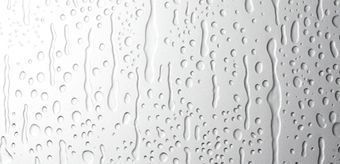 Primer plano de una superficie blanca con gotas de agua y rayas en relieve.