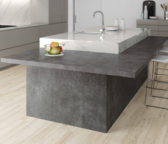 Isla de cocina gris con encimera blanca y un frutero sobre la encimera.