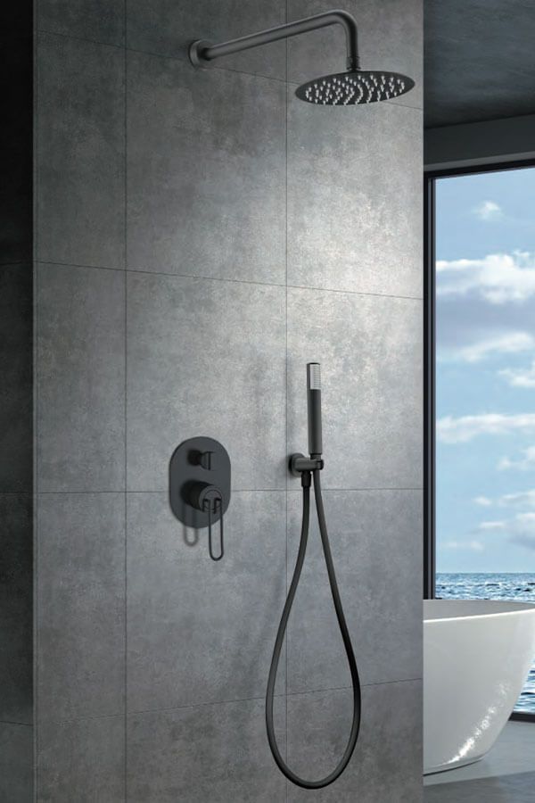 Artefacto de ducha negro con cabezal de ducha tipo lluvia, ducha de mano y controles montados en la pared sobre pared de azulejos grises.