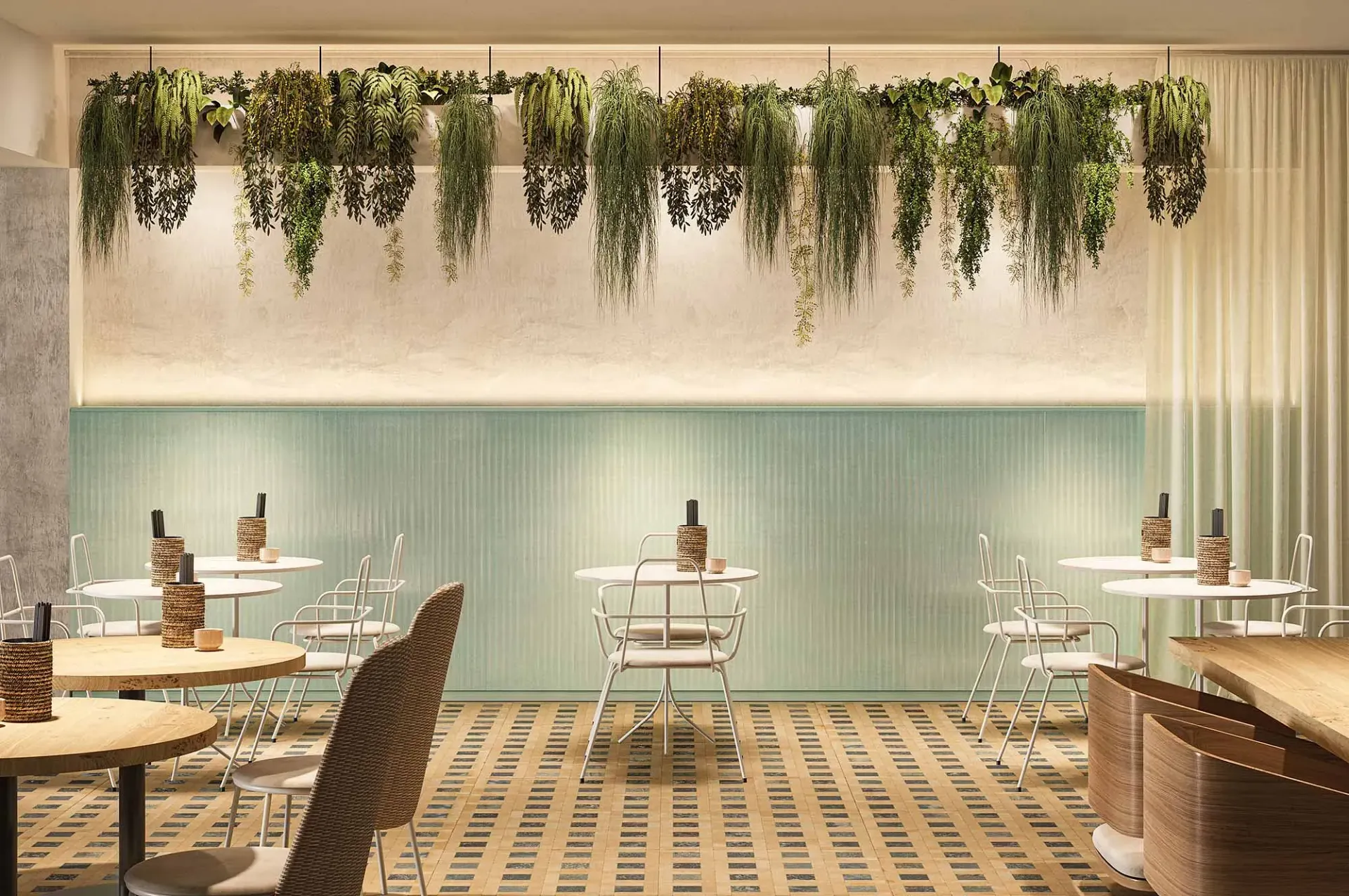 Interior de restaurante con plantas colgantes, mesas blancas y suelo estampado.