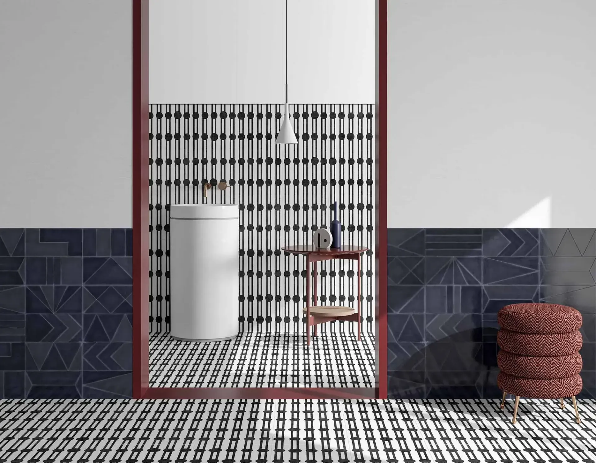 Baño con diseños geométricos de azulejos en negro, blanco y azul, que incluye un lavabo y un taburete.