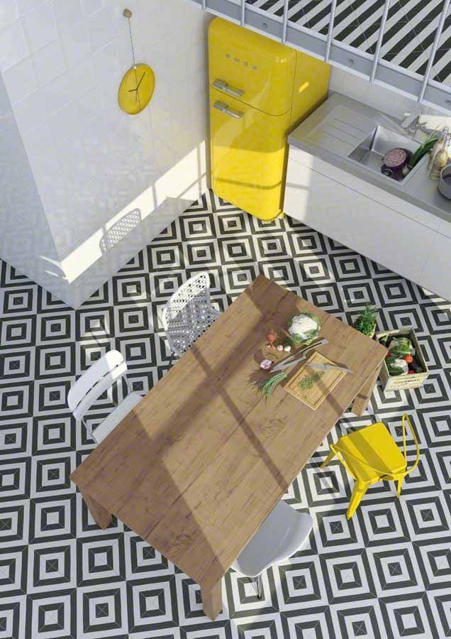 Cocina con nevera amarilla, mesa de madera, suelo estampado y un reloj amarillo.