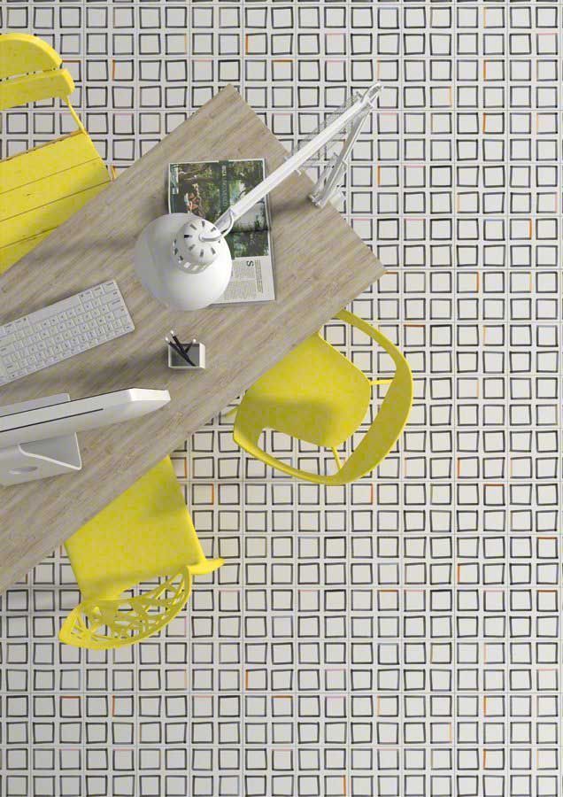 Una mesa con un libro, un teclado y una maqueta de avión, rodeada de sillas amarillas. Suelo de baldosas cuadradas.