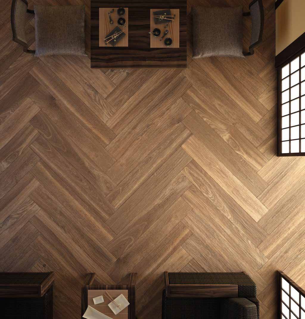 Vista aérea de una habitación con suelo de parquet, una mesa pequeña, sillas y ventana.