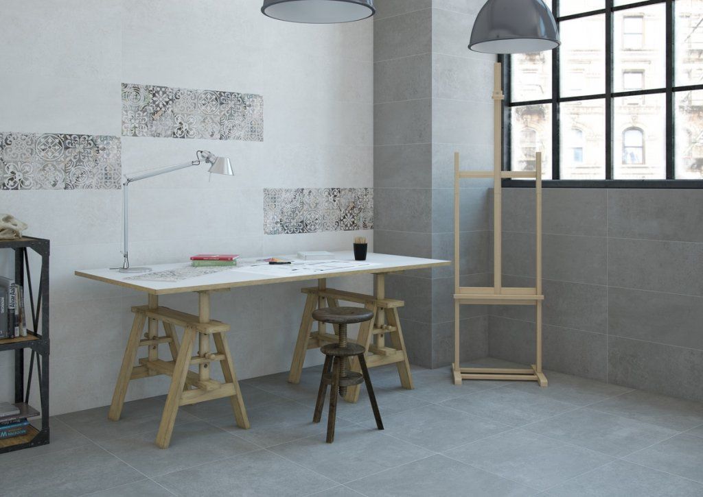 Estudio de arte con un gran escritorio, caballete y una ventana.