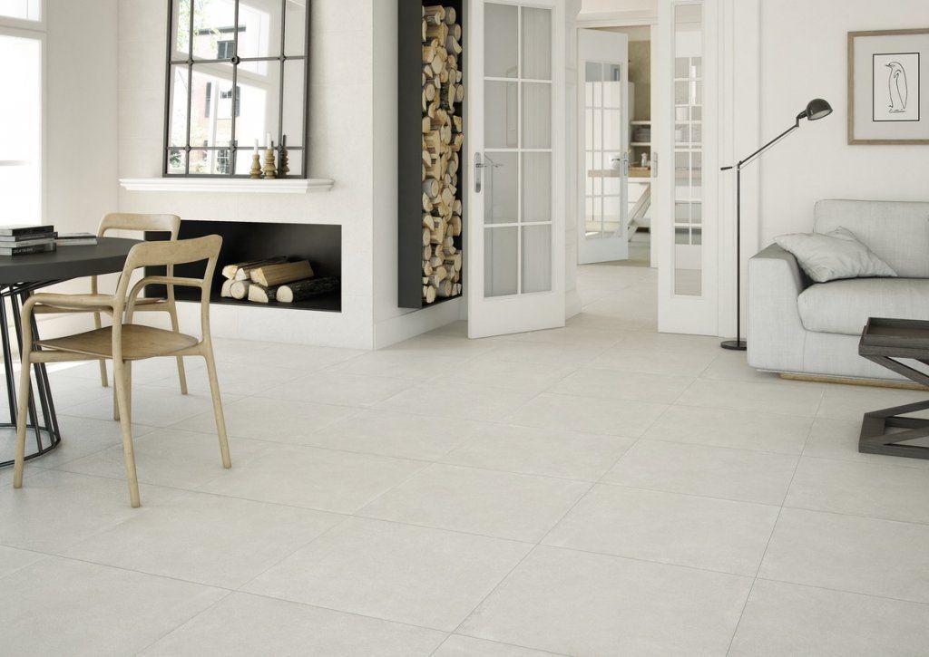 Sala de estar amplia y luminosa con suelo de baldosas blancas, chimenea y muebles modernos.