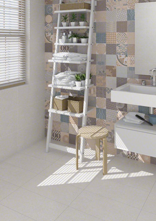 Interior de baño con estante de escalera blanco contra una pared estampada, accesorios blancos y piso de color claro.