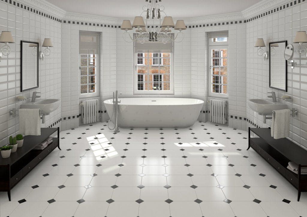 Elegante baño en blanco y negro con bañera independiente, lavabos y suelo de baldosas decorativas.
