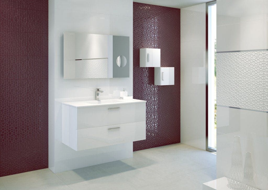 Baño blanco moderno con tocador flotante, gabinetes y una pared con acento texturizado de color burdeos.