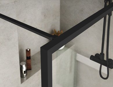 Marco de ducha de color negro, cabezal de ducha y estante de esquina con artículos de tocador en un baño moderno.