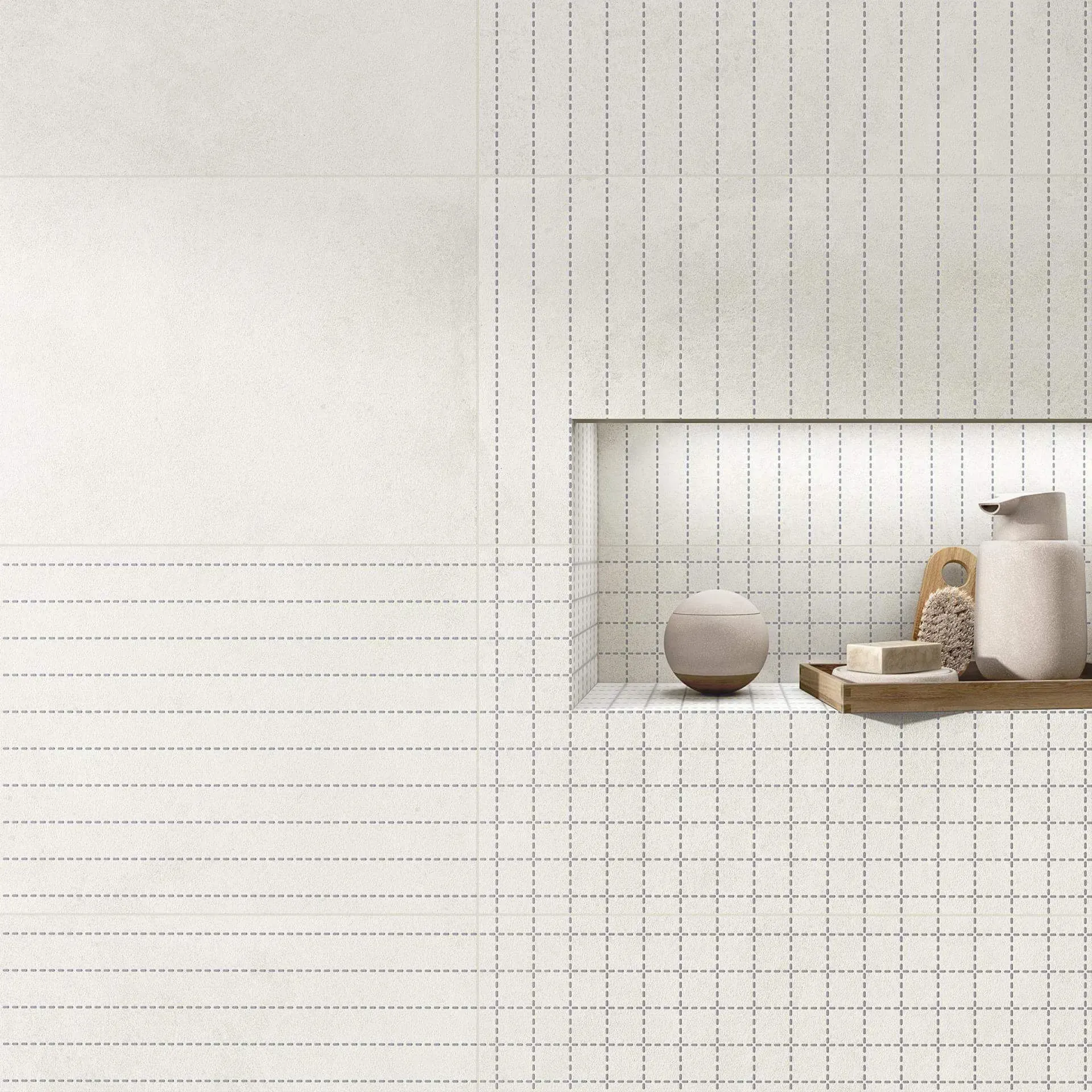 Pared de baño con azulejos blancos y un estante incorporado que contiene artículos de tocador.