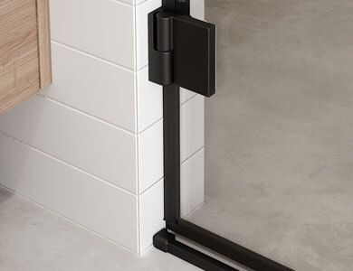 Bisagra de puerta de ducha negra fijada a pared y suelo de azulejos blancos.