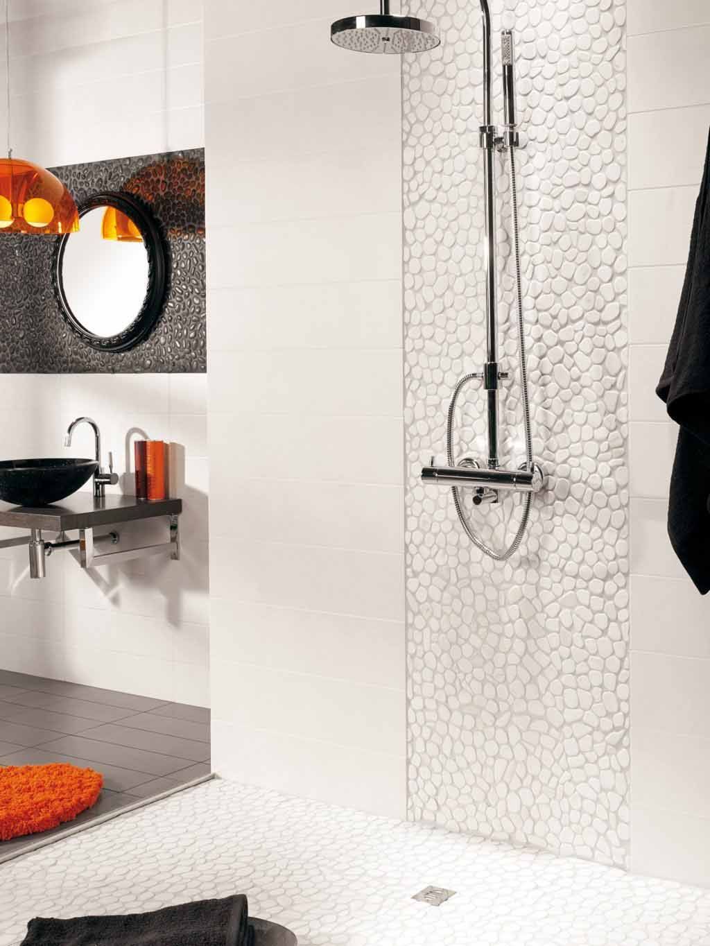 Baño moderno con ducha, paredes blancas, detalles de azulejos de guijarros y detalles en naranja.