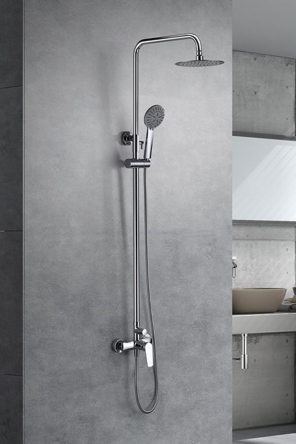 Sistema de ducha cromado con cabezal de ducha de lluvia y rociador de mano contra una pared gris.