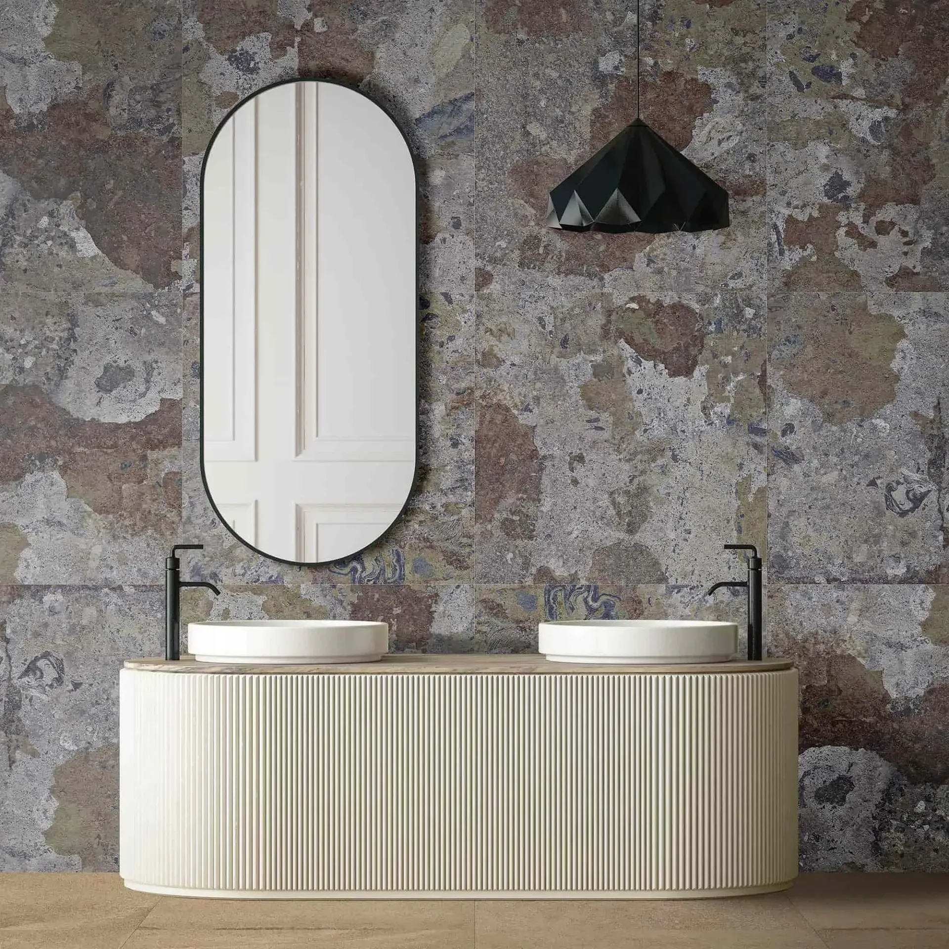Baño con dos lavabos, espejo ovalado, pared estampada y lámpara colgante geométrica.