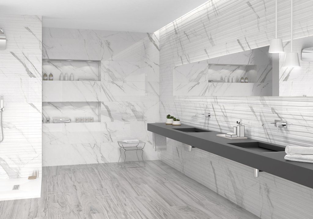 Baño moderno de mármol blanco con lavabos dobles y estanterías empotradas.