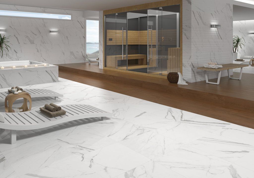 Spa de lujo con suelo de mármol blanco, sauna y zona de relajación con vistas a un cuerpo de agua.